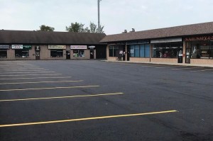 Freshly paved parking lot with bright yellow lines in a plaza